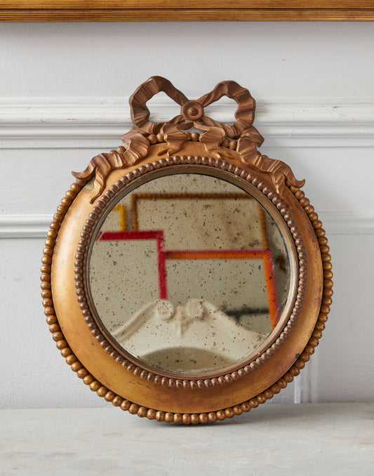 A Circular Gilt Bronze Mirror with Ribbon Bow Decoration