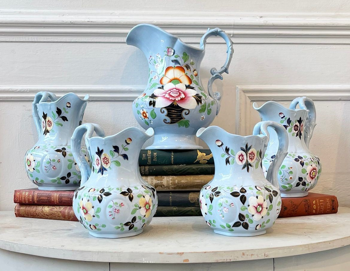 A Collection of Fifteen Pale Blue Stoneware PitcherJugs Handpainted with Flowers and Gilded Accents by William Ridgway circa 1840s