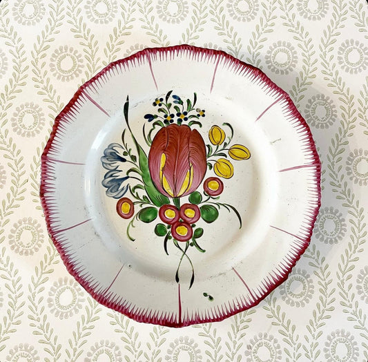 A French Faience Plate with a Tulip and Other Flowers within a Feathered Rim, Circa 1800.