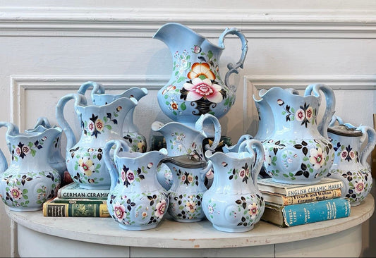 A Collection of Fifteen Pale Blue Stoneware PitcherJugs Handpainted with Flowers and Gilded Accents by William Ridgway circa 1840s