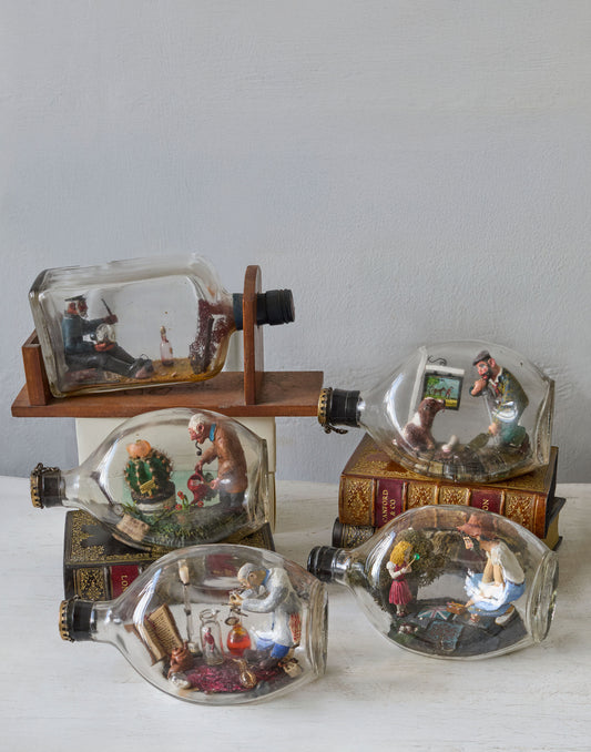 A Collection of Seven Vintage 'Ships in Bottles', each Modelled with Interior Scenes made 1950s-1970s